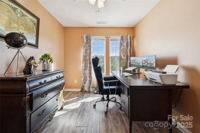 a kitchen with a stove a sink and a dining table with wooden floor