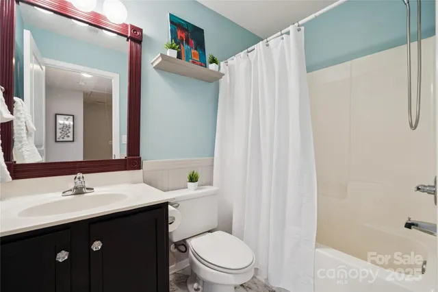 a bathroom with a sink vanity mirror and toilet