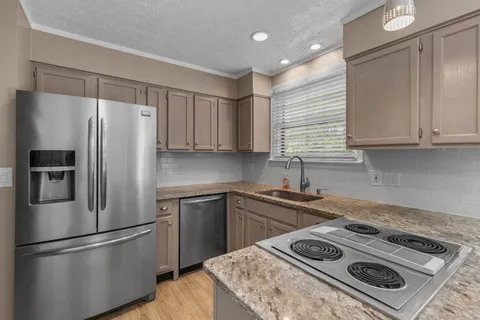 a kitchen with a stove a refrigerator and a sink