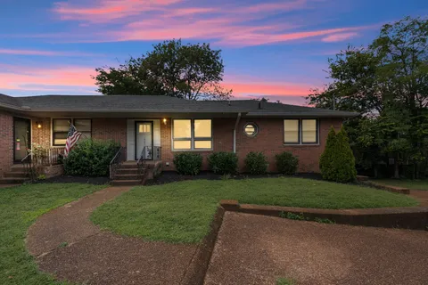 a front view of a house with a garden and yard
