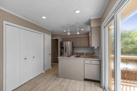 a kitchen with a refrigerator a sink and wooden floor