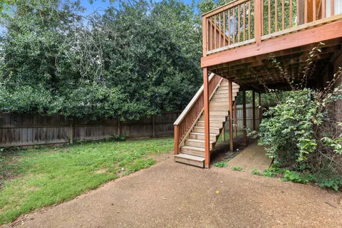a view of a house with backyard and deck