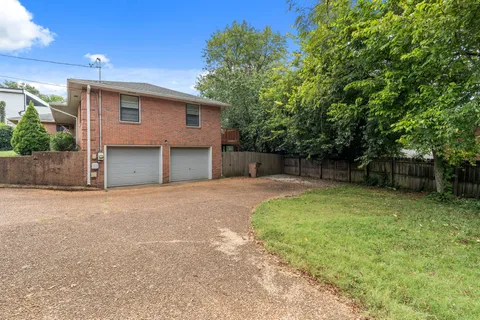 a backyard of a house with plants and tree