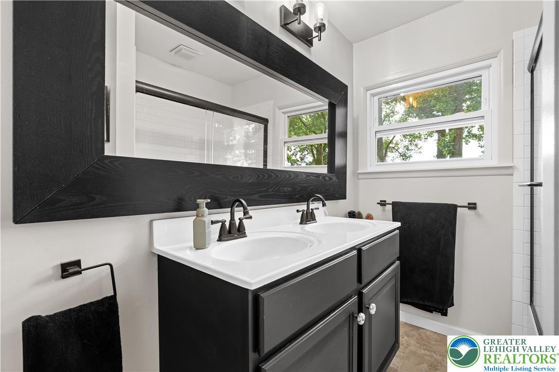 2569 Woods Edge Road Bath, PA 18014 - Photo 18 of 40 A stylish double vanity and tiled flooring anchor this updated modern bathroom.