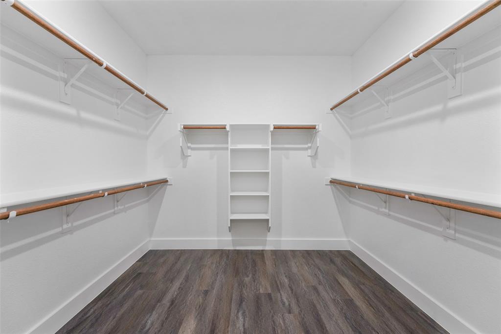 122 East Beachwood Loop Trinidad, TX 75163 - Photo 25 of 35 Spacious walk-in closet featuring wood-finish flooring, white walls, built-in shelving, and multiple clothing rods