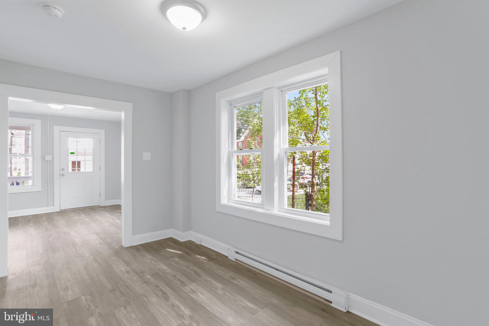 440 Jonathan Street, Unit A Hagerstown, MD 21740 - Photo 5 of 21 an empty room with wooden floor and windows