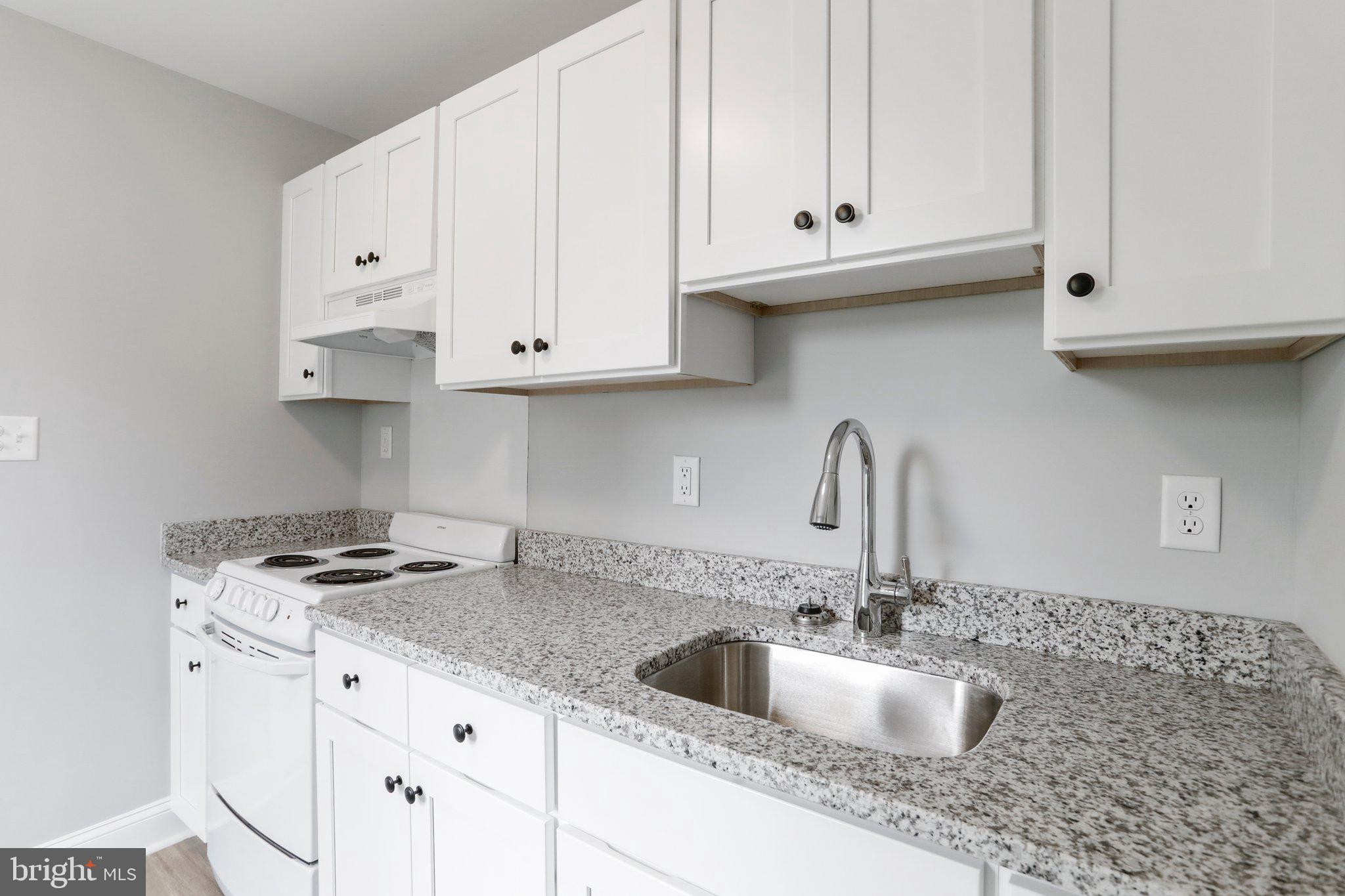 440 Jonathan Street, Unit A Hagerstown, MD 21740 - Photo 6 of 21 a kitchen with granite countertop a sink a stove and cabinets