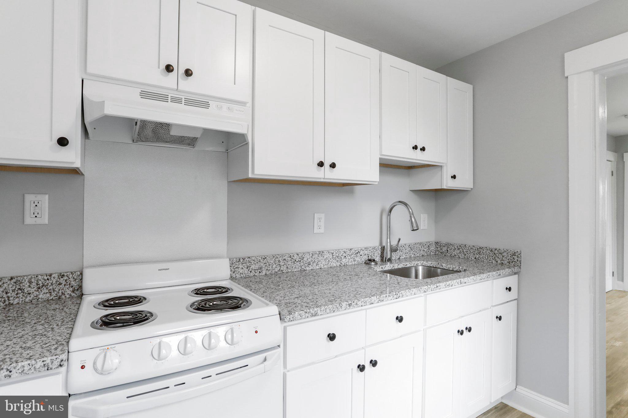 440 Jonathan Street, Unit A Hagerstown, MD 21740 - Photo 7 of 21 a kitchen with granite countertop white cabinets and white stove