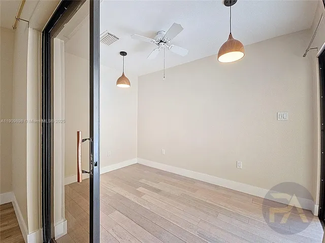 a view of a room with wooden floor and white walls