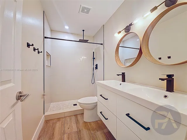 a bathroom with a sink a toilet and shower