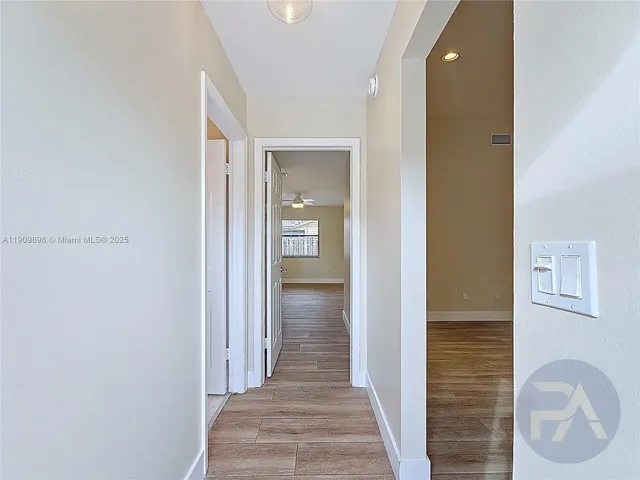 a view of a hallway with wooden floor and closet