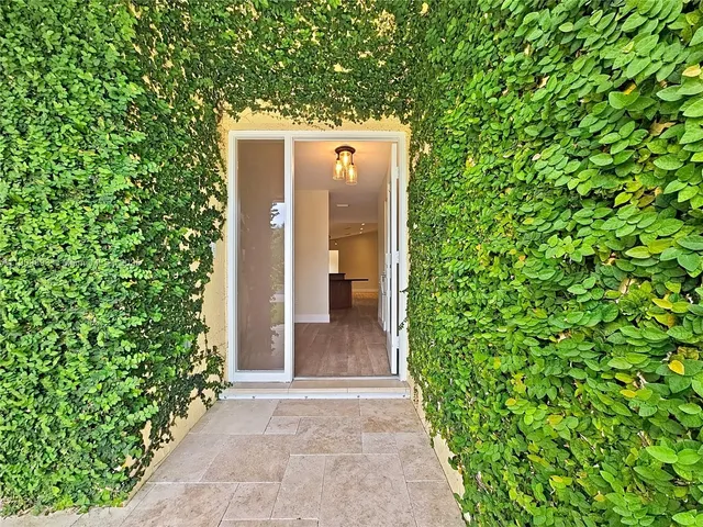 a front view of a house with a yard and potted plants