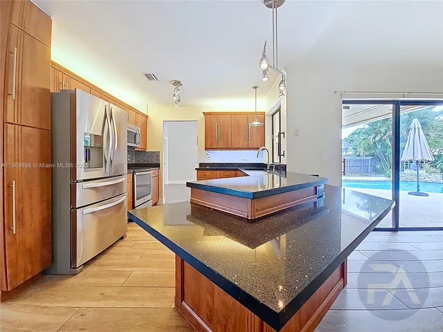 a kitchen with stainless steel appliances granite countertop a refrigerator and a stove