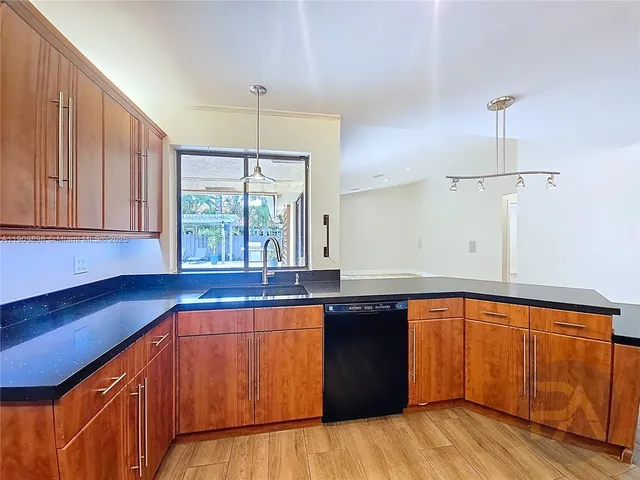 a kitchen with a sink a window stainless steel appliances and cabinets
