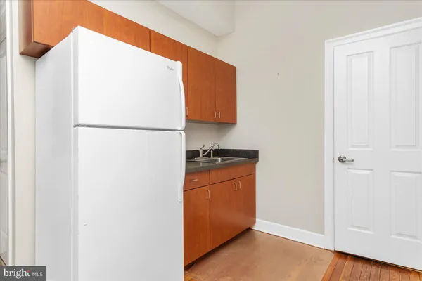 a white refrigerator freezer and a wooden floor