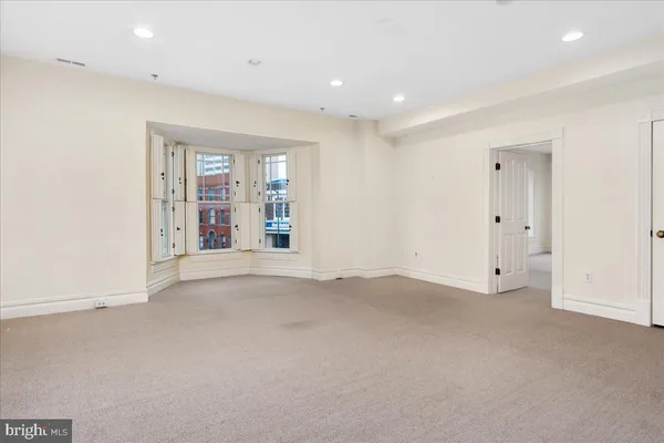 an empty room with windows and closet