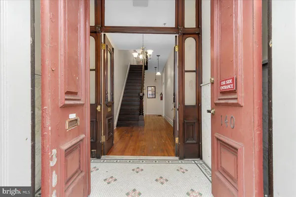 a view of a hallway with wooden floor and entryway