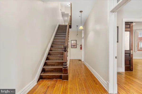 a view of a hallway with wooden floor and entryway