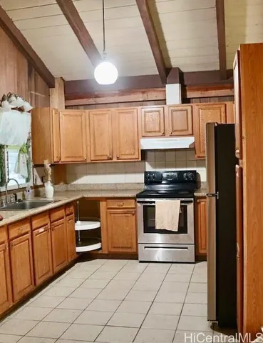 a kitchen with stainless steel appliances granite countertop a stove a sink and a refrigerator