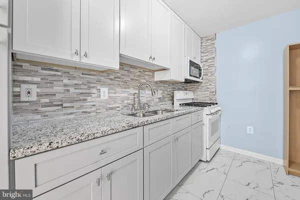 a kitchen with granite countertop a sink and cabinets