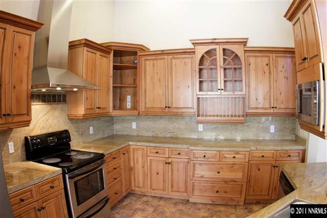 a kitchen with granite countertop a sink a stove and cabinets