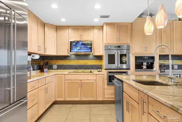 a kitchen with stainless steel appliances granite countertop a stove sink and cabinets