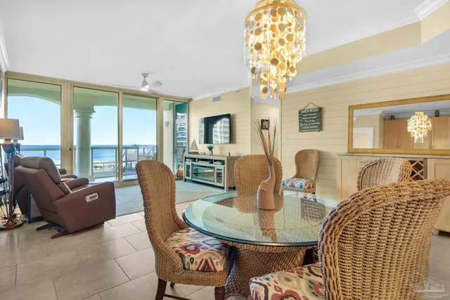 a living room with furniture a chandelier and a dining table