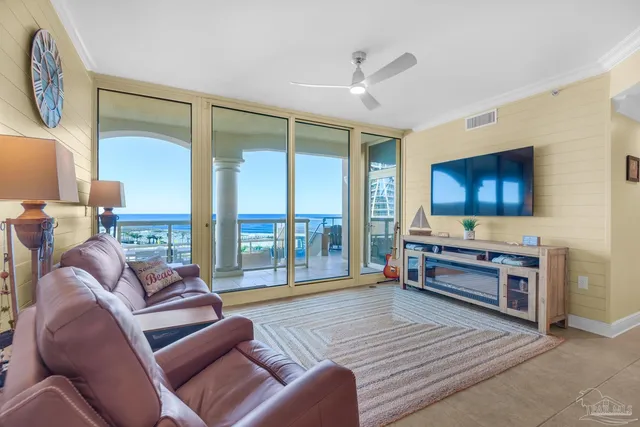 a living room with furniture a flat screen tv and a floor to ceiling window