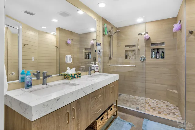 a bathroom with a sink mirror and a shower