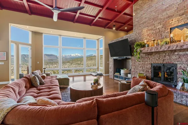a living room with furniture fireplace and a large window