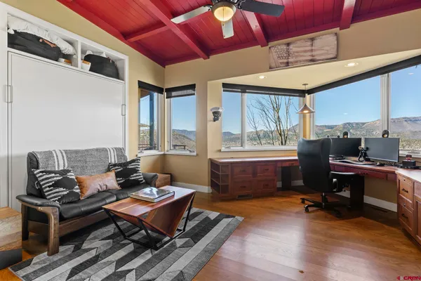 a living room with furniture a wooden floor and a large window