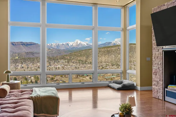 a living room with furniture large windows and flat screen tv
