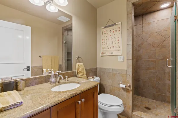 a bathroom with a granite countertop sink toilet and shower