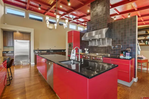 a kitchen with stainless steel appliances granite countertop a sink a stove and a wooden floors