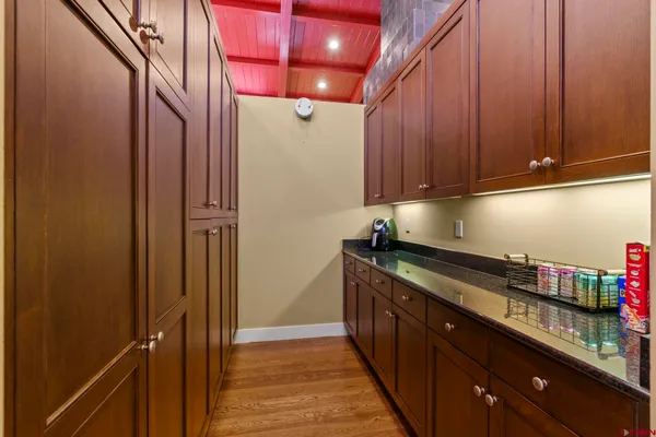 a kitchen with stainless steel appliances granite countertop a sink a stove and a refrigerator with wooden cabinets
