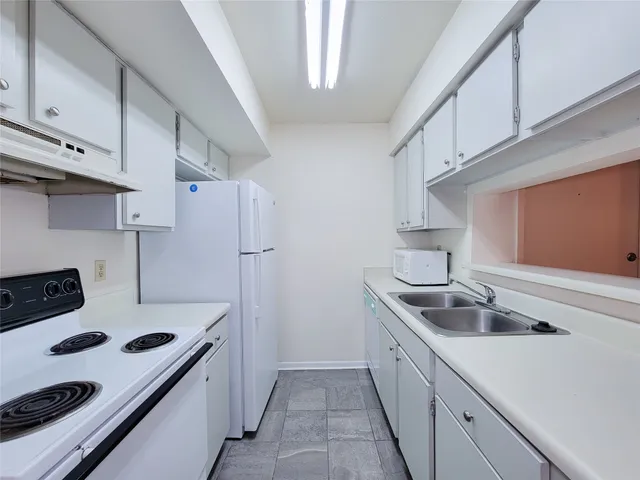 a kitchen with stainless steel appliances a sink a stove and refrigerator