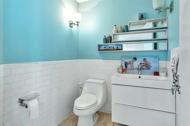 a white toilet sitting next to a bathroom sink