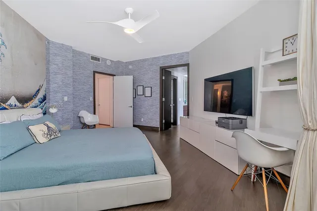 a bedroom with a bed and a flat screen tv