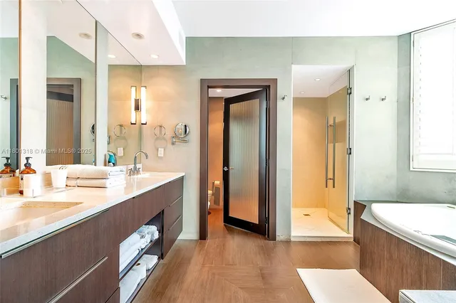 a bathroom with a tub sink and mirror