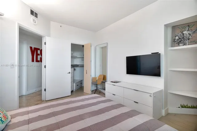 a hotel room with a bed and a flat screen tv