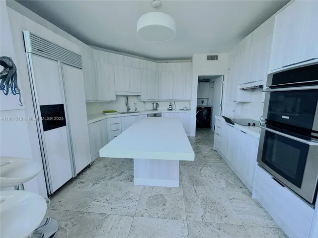 a kitchen with a sink a microwave a refrigerator and cabinets