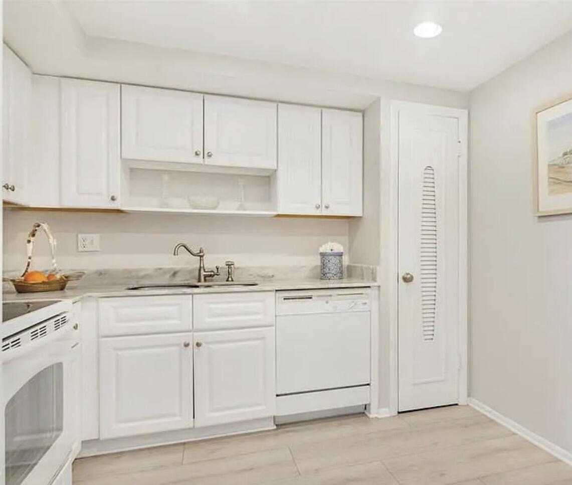 3800 Washington Road, Unit 310 West Palm Beach, FL 33405 - Photo 3 of 14 a kitchen with white cabinets and white appliances