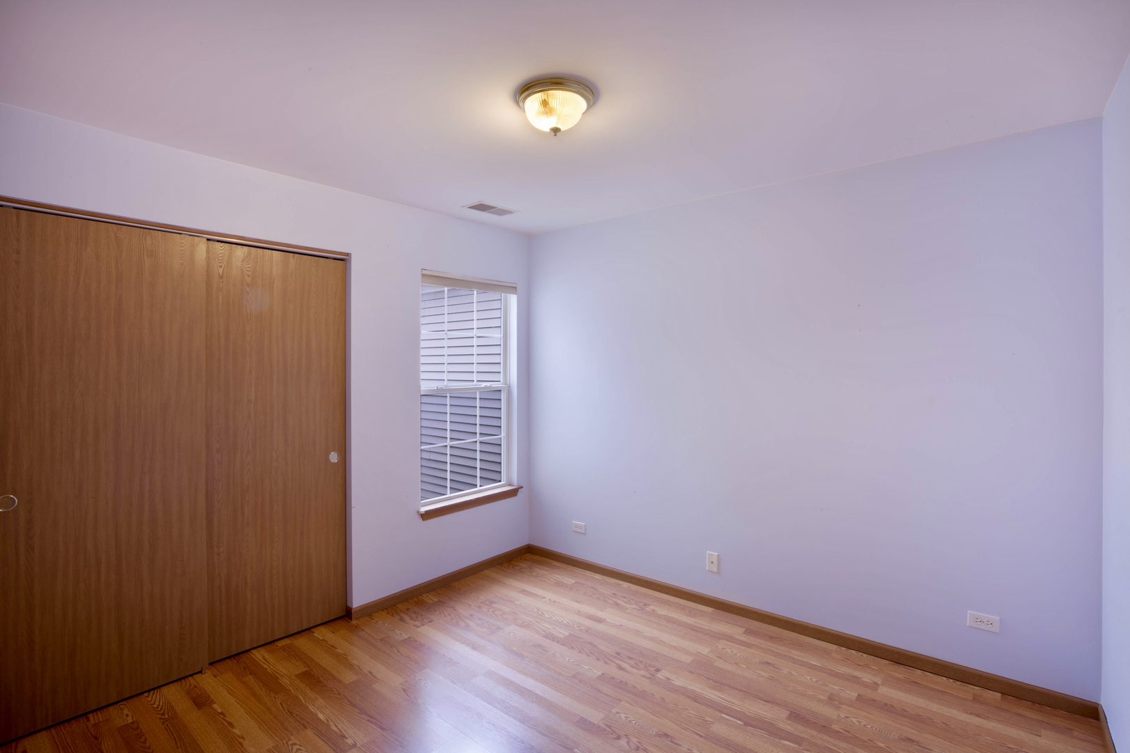 4736 Lacey Avenue Lisle, IL 60532 - Photo 11 of 20 a view of an empty room with wooden floor and a window