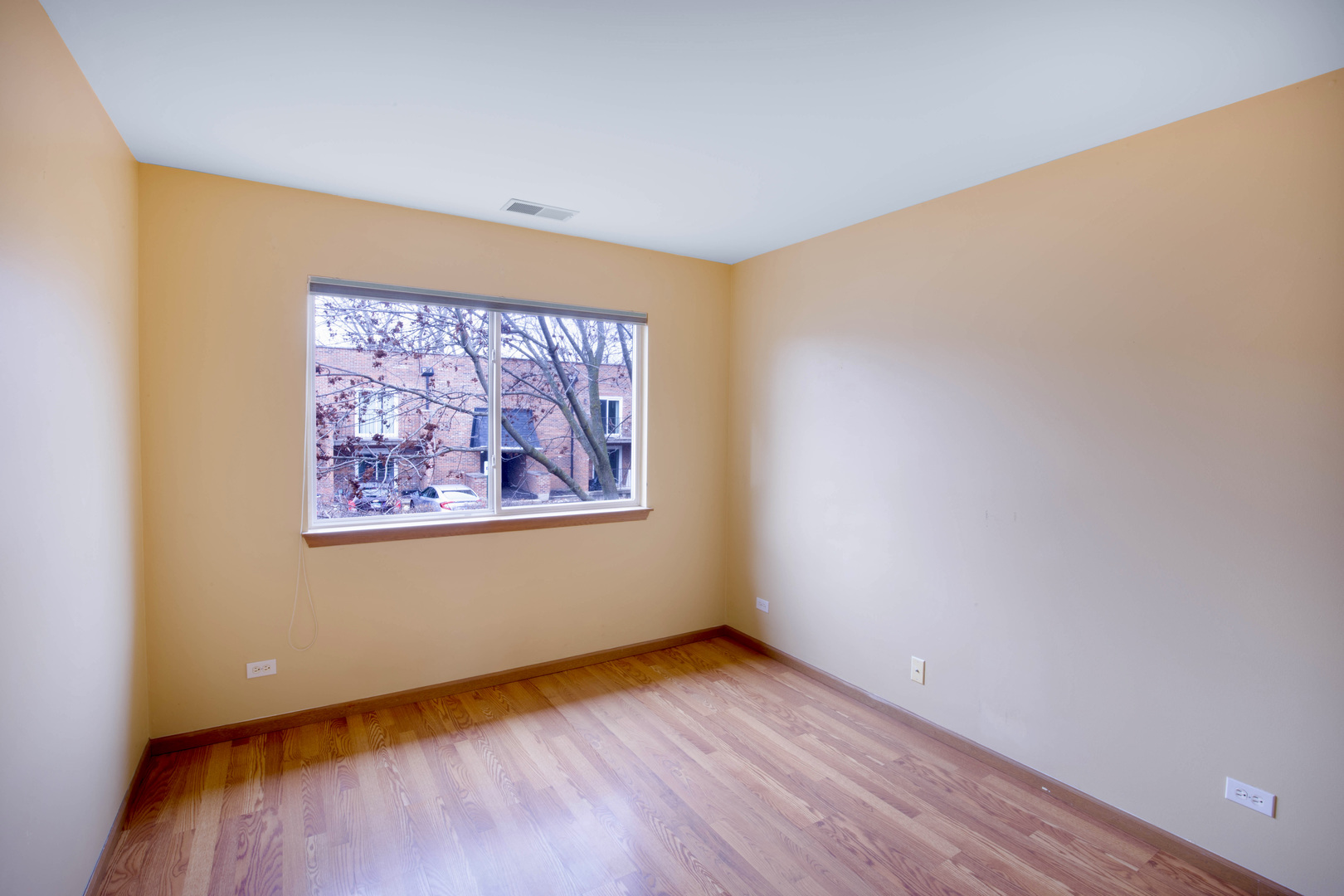4736 Lacey Avenue Lisle, IL 60532 - Photo 12 of 20 a view of an empty room with wooden floor and a window