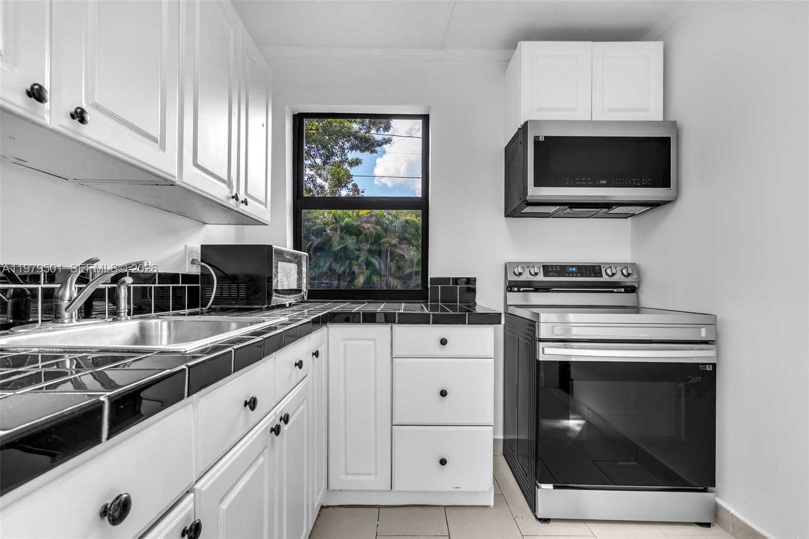 130 Southwest 31st Court, Unit 2 Miami, FL 33135 - Photo 8 of 14 a kitchen with stainless steel appliances a stove a microwave sink and cabinets