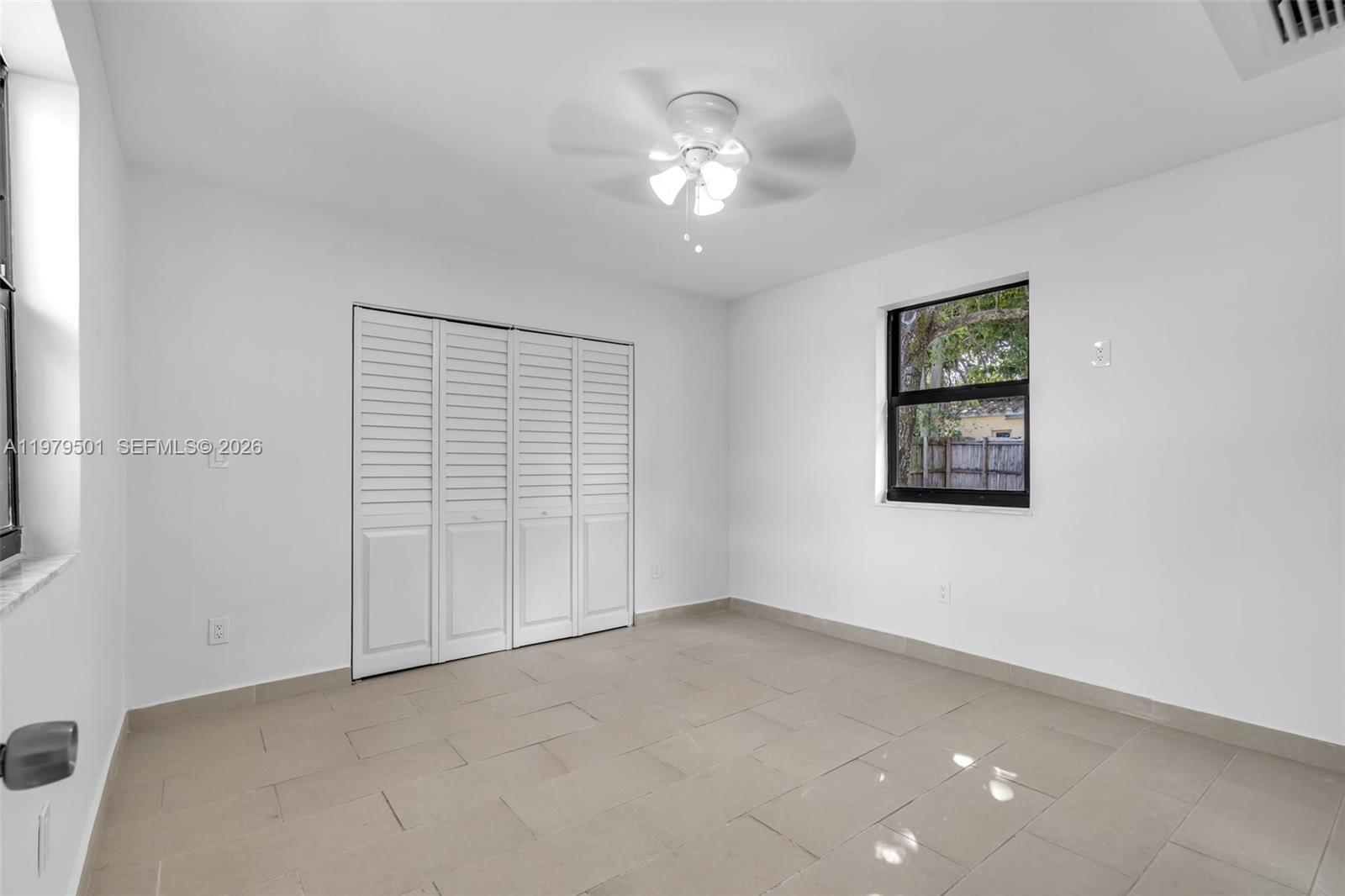 130 Southwest 31st Court, Unit 2 Miami, FL 33135 - Photo 10 of 14 an empty room with a ceiling fan and window
