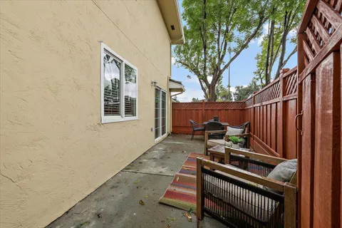 a view of backyard with wooden fence and trees