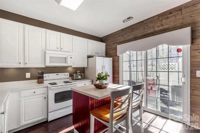 a kitchen with a stove a table and chairs in it