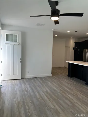 a view of a big room with wooden floor and windows