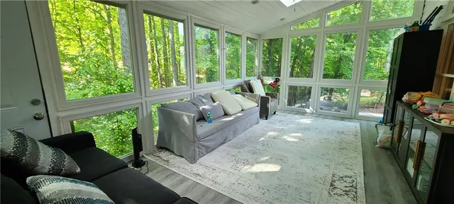a living room with patio furniture and a floor to ceiling window
